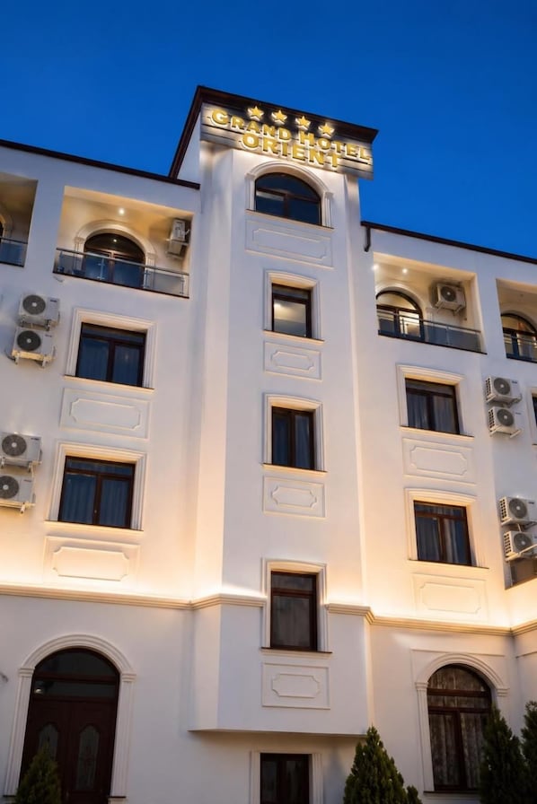 A multi-story hotel with a prominent sign reading 'Grand Hotel Orient'.