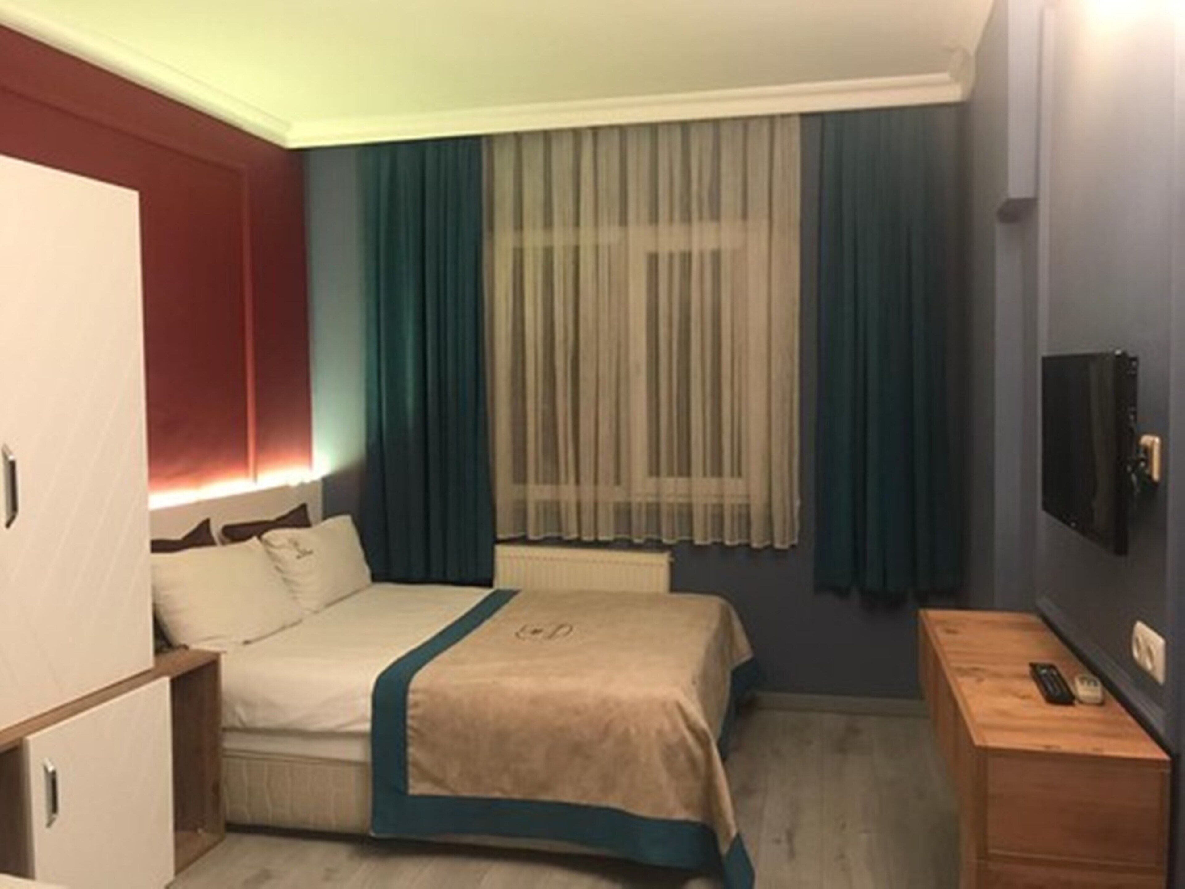 A compact hotel room with a bed, bedside table, and a television.