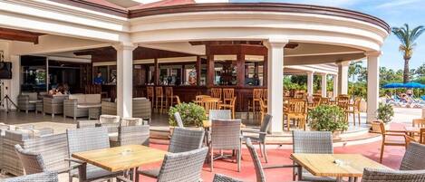 An outdoor seating area with wicker furniture and a bar.