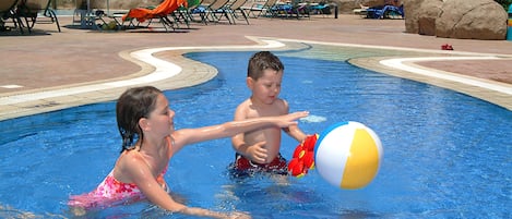 Una piscina con sillas de descanso y sombrillas.