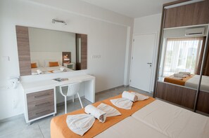 A modern hotel room with a large bed, a desk, a chair, and a wardrobe. - La Casa Di Napa (Ayia Napa)