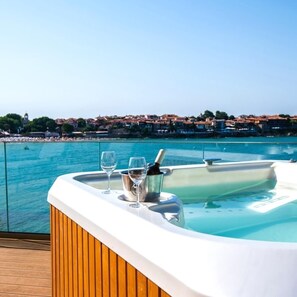 A hot tub with two glasses and a bottle, overlooking a coastal town. - Hotel Antea Sozopol – By The Sea (Sozopol)