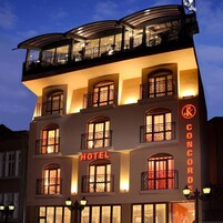 A hotel with a prominent 'HOTEL' sign, balconies with wrought iron railings, and a 'SKY BAR' sign at the top.