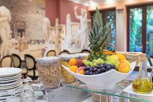 A breakfast buffet with a variety of fruits and a pineapple centerpiece.