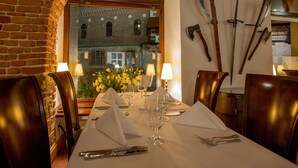 A dining table set for four with a view of a historic building through a window. - Hotel Polski Pod Białym Orłem (Kraków)