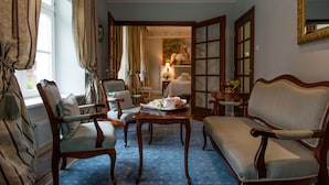 A traditional room with a blue patterned carpet, wooden furniture, and a painting on the wall. - Hotel Polski Pod Białym Orłem (Kraków)