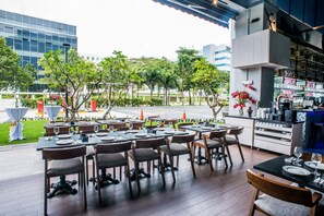 Enjoy dining al fresco amidst lush greenery and city views.