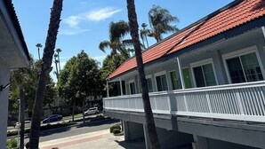 A building with a red-tiled roof and a white balcony. Tall palm trees are visible in the foreground. - Garden Inn Hotel 花園酒店 - Pasadena, San Gabriel - Los Angeles (Temple City)