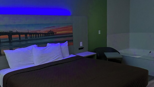 A hotel room with a bed, a nightstand, a desk, and a wall-mounted TV. - Garden Inn Hotel 花園酒店 - Pasadena, San Gabriel - Los Angeles (Temple City)
