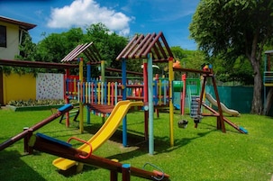 Un parque infantil con diversas estructuras de juego, incluyendo toboganes y zonas de escalada.