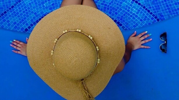 A person lying in a pool with a straw hat and sunglasses. - Hotel & Villas Huetares (Sardinal)