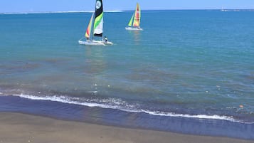Sulla spiaggia, sabbia scura, teli da spiaggia