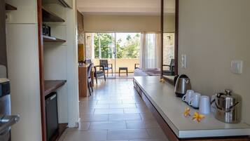 A modern kitchen with a dining area, a small table, and a view of the outdoors.