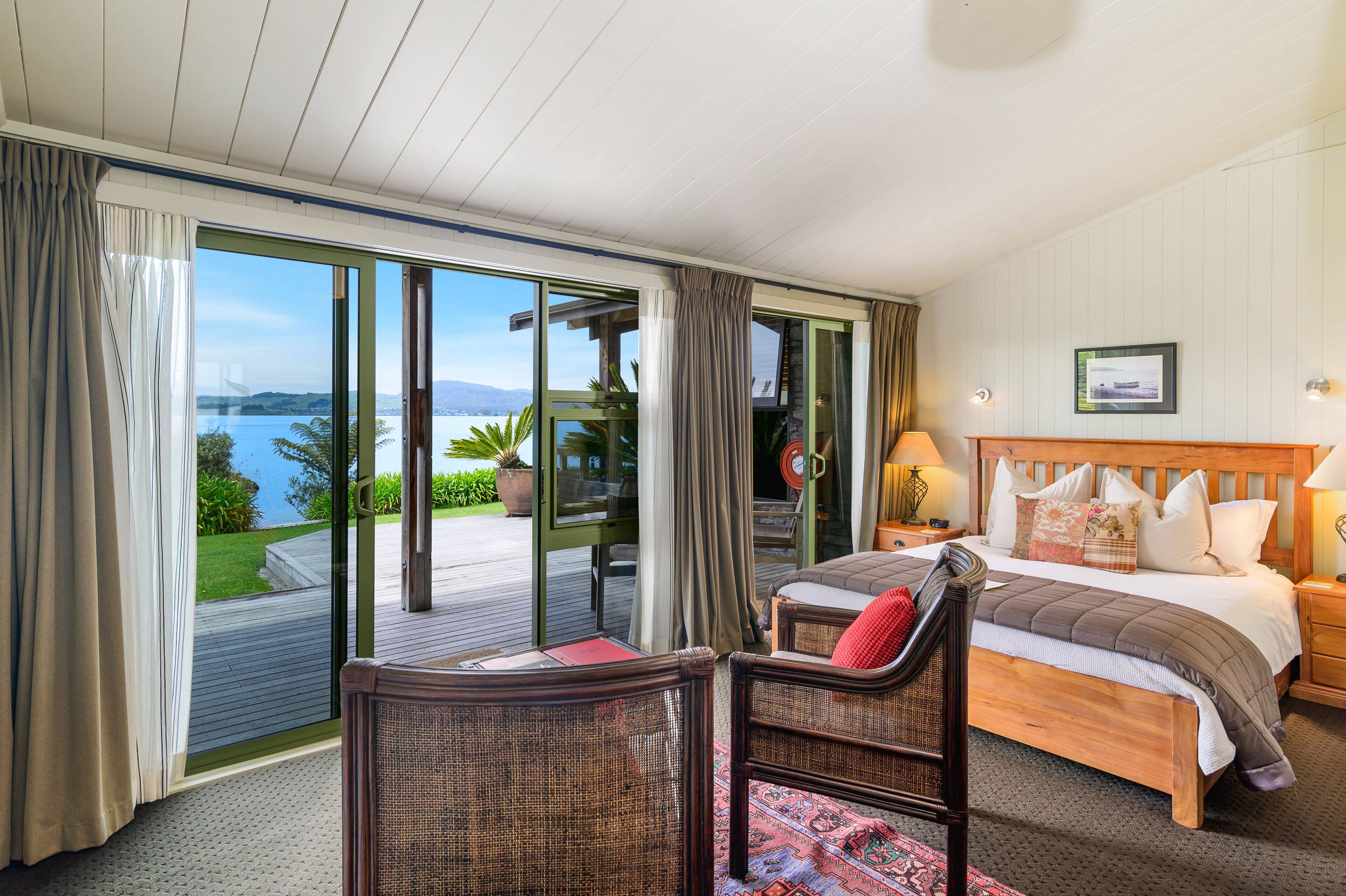 Un dormitorio con un amplio ventanal corredera que da a un balcón con vistas al mar.
