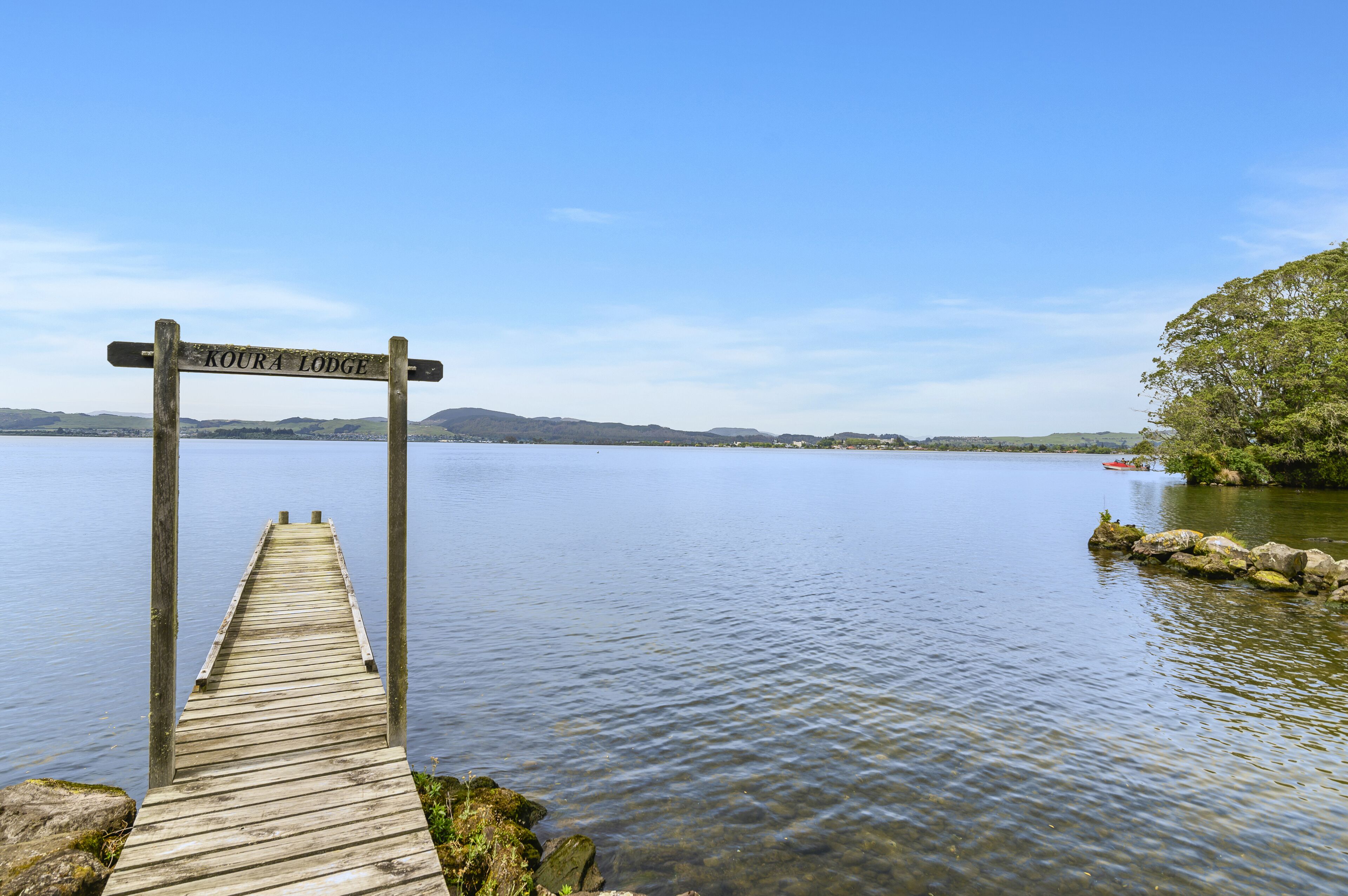 A wooden dock leading to a sign that reads "Koura Lodge."