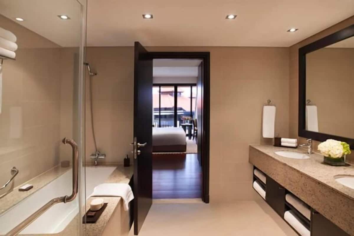 Een moderne badkamer met een douche, een bad, een wastafel en een grote spiegel.