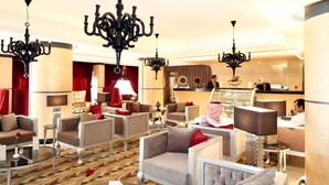A hotel lobby with modern furniture, chandeliers, and a bar area. - Grand Plaza Hotel - Takhasosi Riyadh (Riyadh)
