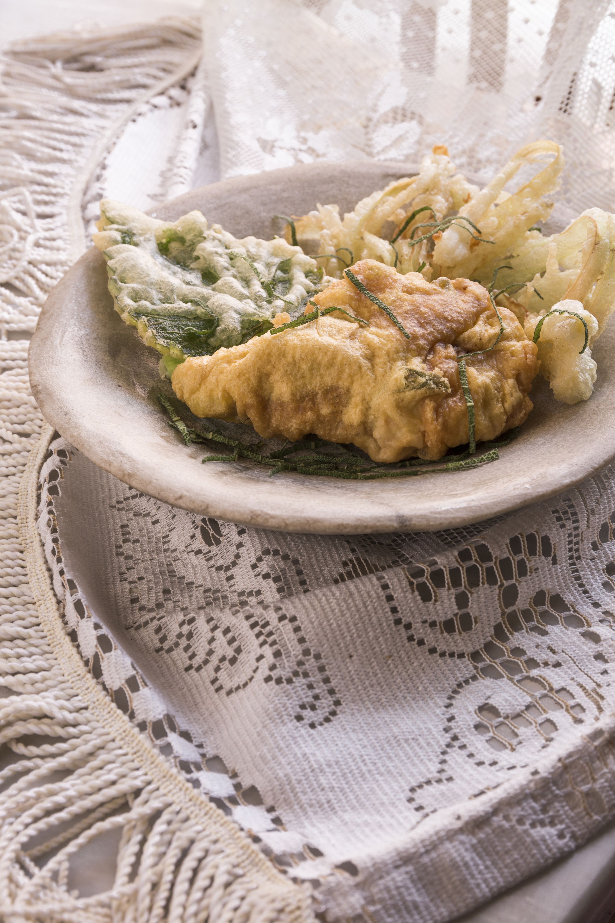 A plate of food on a lace tablecloth.
