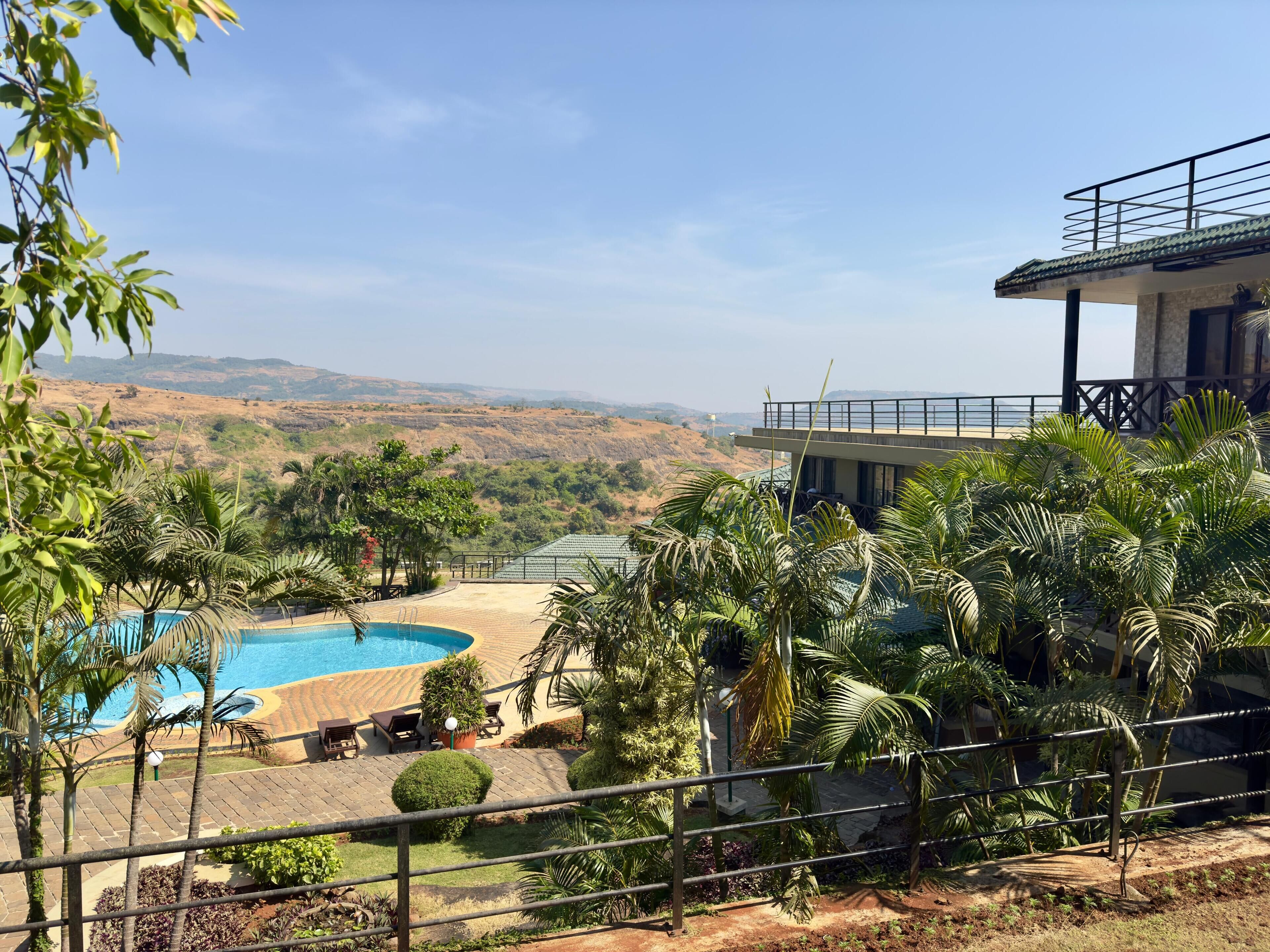 A pool area with a view of a hilly landscape.
