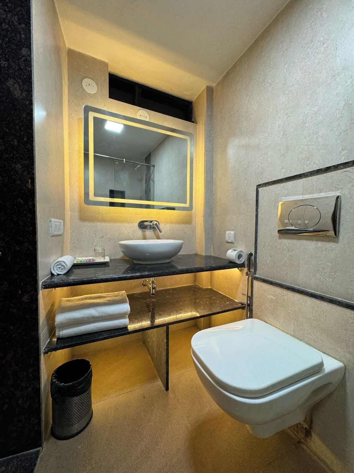Ein modernes Badezimmer mit Waschbecken, Spiegel und Toilette.