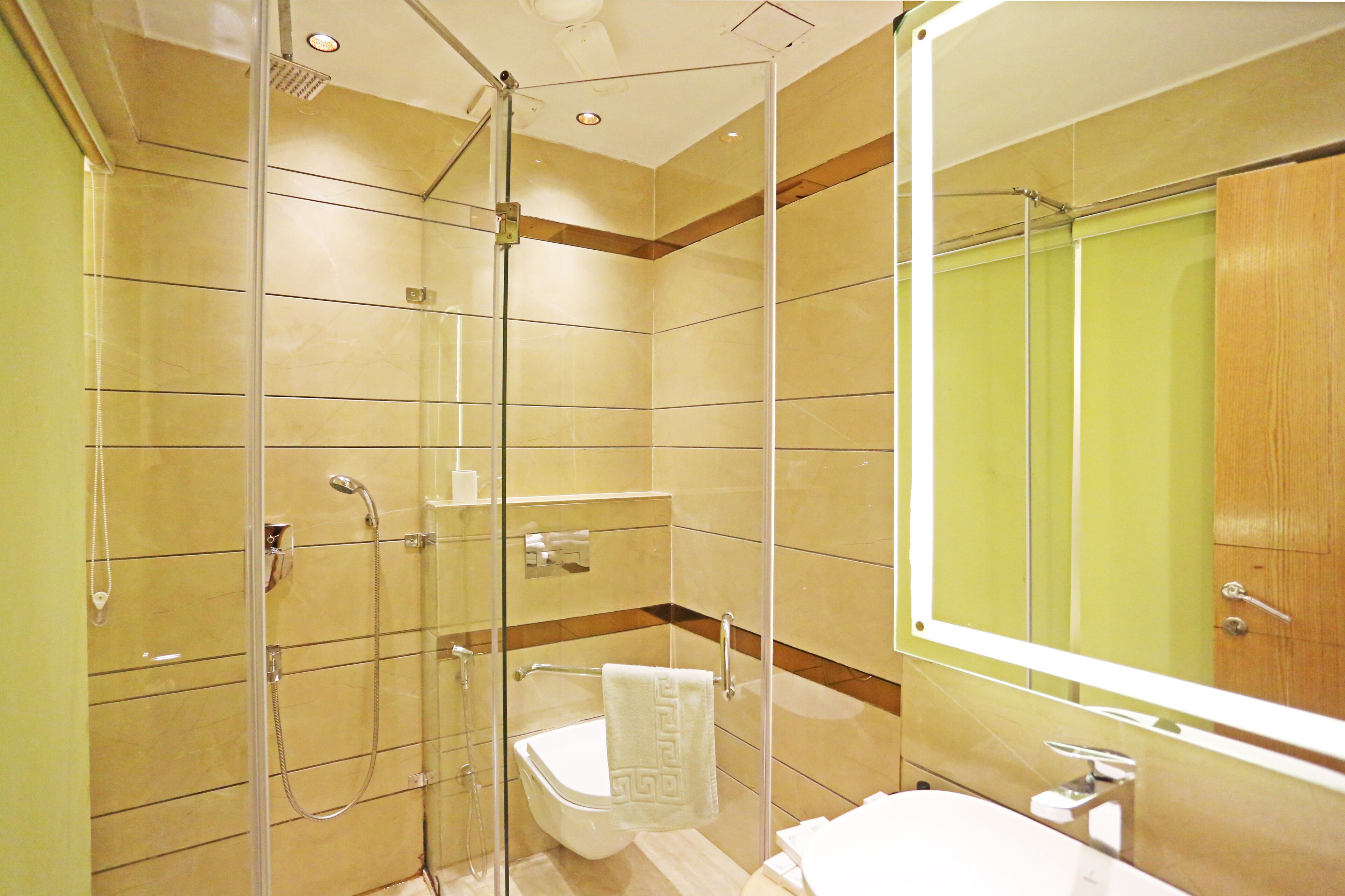 A modern bathroom with a glass-enclosed shower, a white sink, and a large mirror.