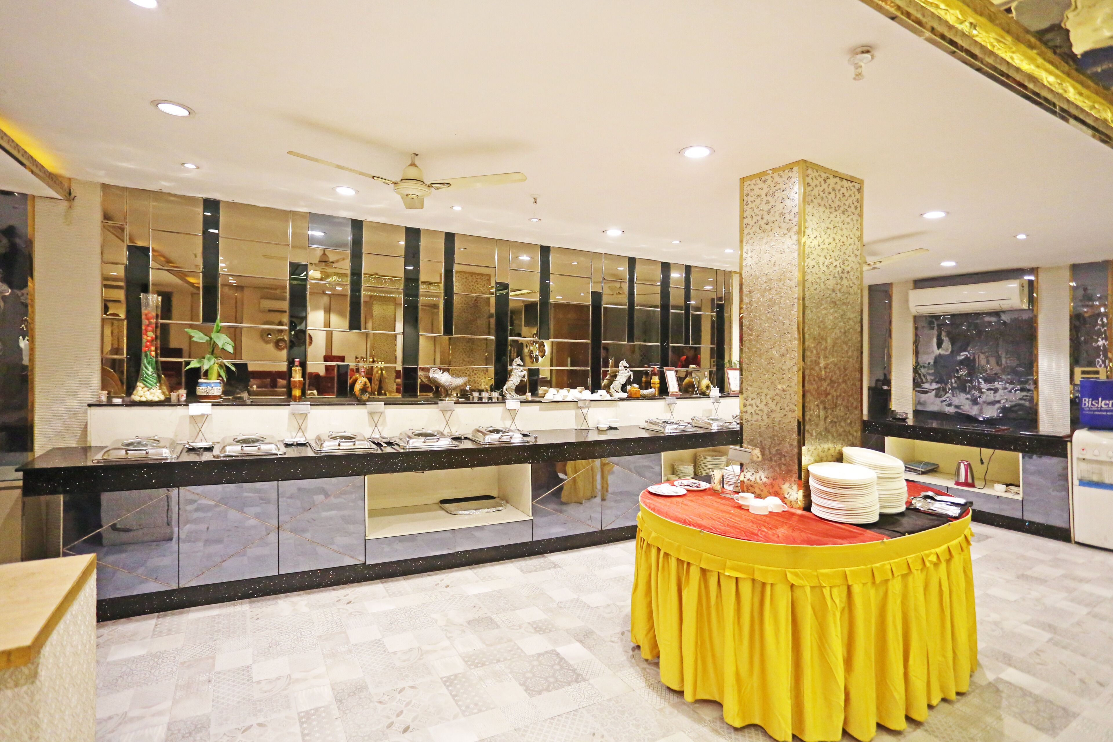 A buffet area with a counter and a central table with a yellow tablecloth.