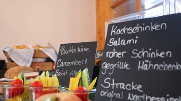 A menu board with various food items and a display of fresh fruits and vegetables.