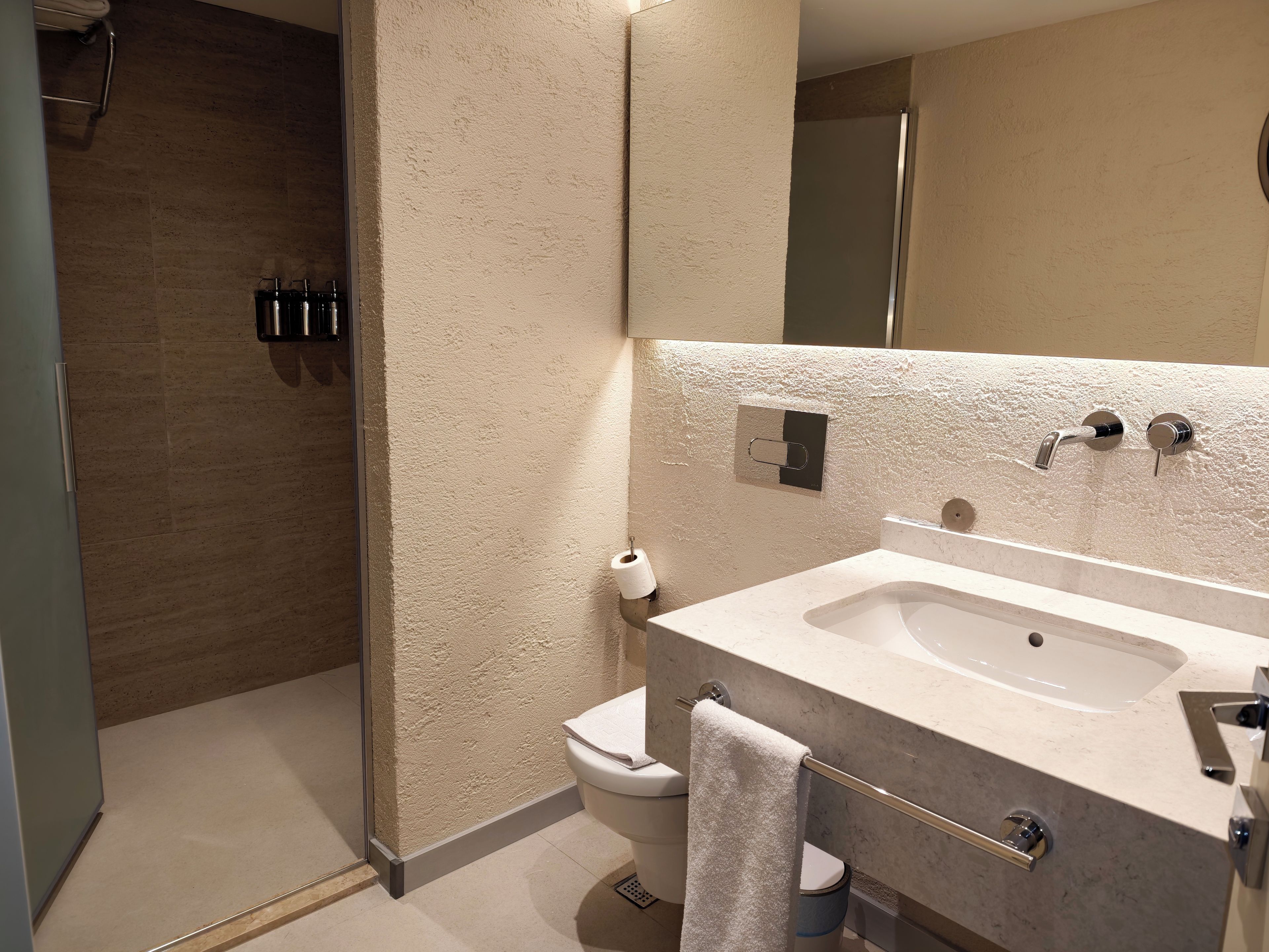 Un baño moderno con ducha, inodoro y lavamanos.