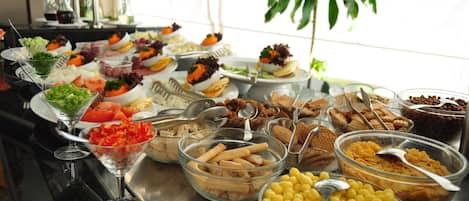 A buffet table with various food items and beverages.