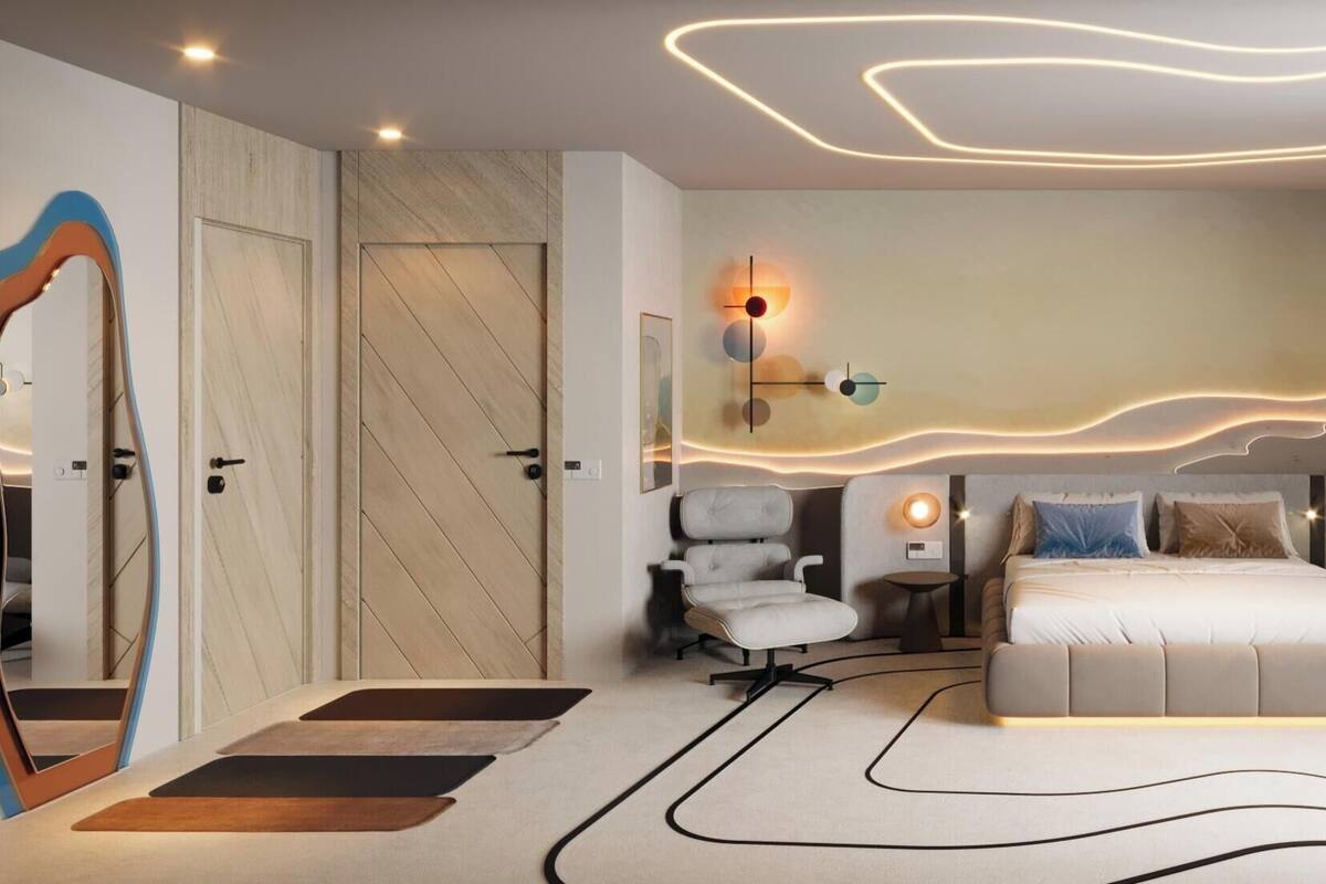 A modern bedroom with a bed, a chair, and a wall-mounted light fixture.