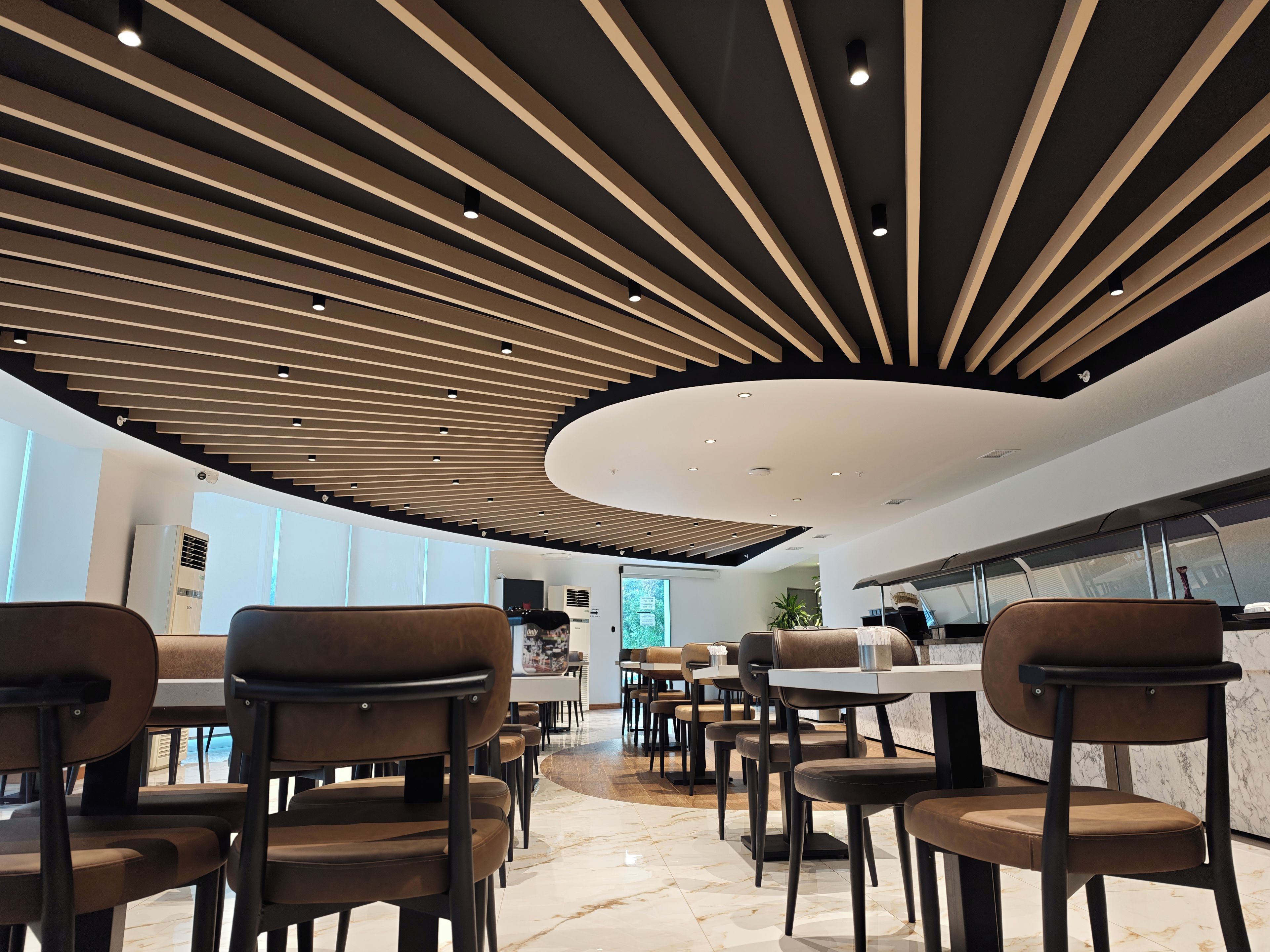 A modern interior with a curved ceiling, seating area, and a kitchen counter.