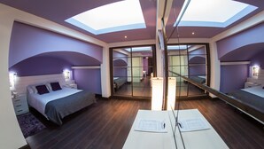 Un dormitorio moderno con tragaluces, un espejo grande y un escritorio con documentos.