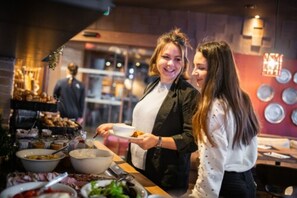 A buffet setup with various food items and a person serving. - Le Hameau du Kashmir (Les Belleville)
