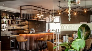 Zona de bar moderna con barra de madera, taburetes y un panel con la carta.