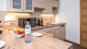 A modern kitchen with wooden cabinets, a built-in microwave, and a stainless steel sink.