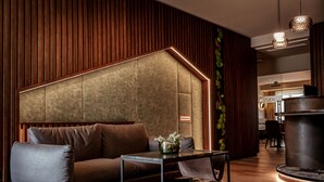 Un espacio lounge moderno con sofá, mesa de centro y plantas decorativas.