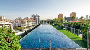 Una piscina larga con un paisaje urbano al fondo.