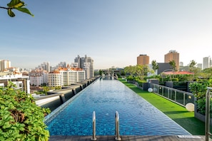 Una piscina larga con un paisaje urbano al fondo.