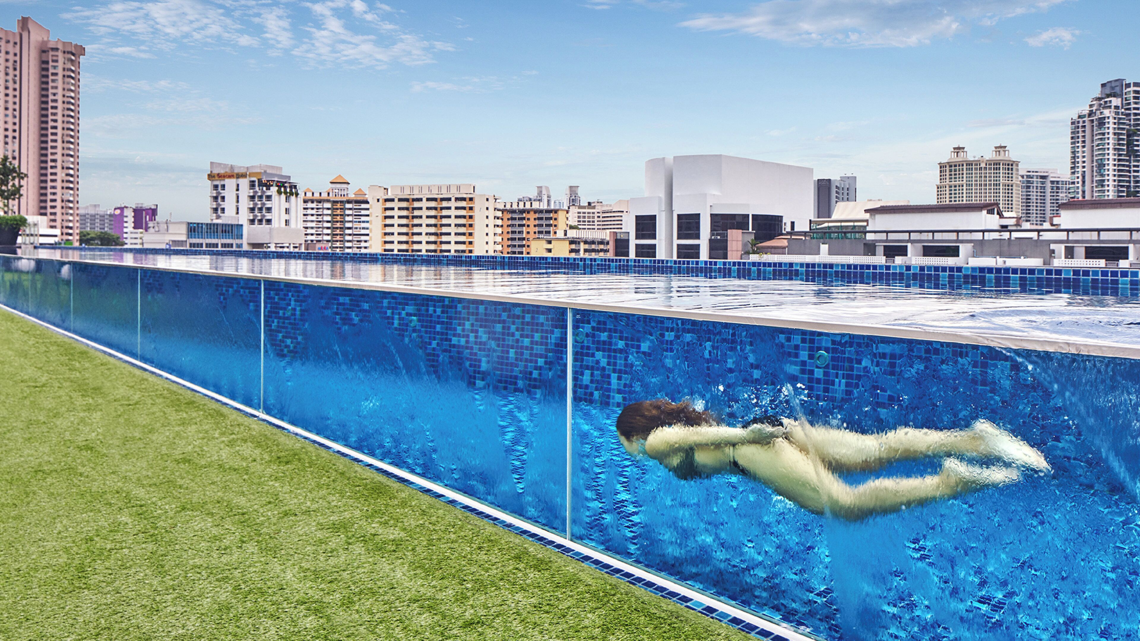 A swimming pool with a cityscape in the background.