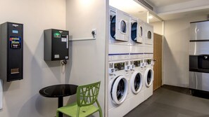 Un cuarto de lavandería con varias lavadoras y una máquina que funciona con monedas.