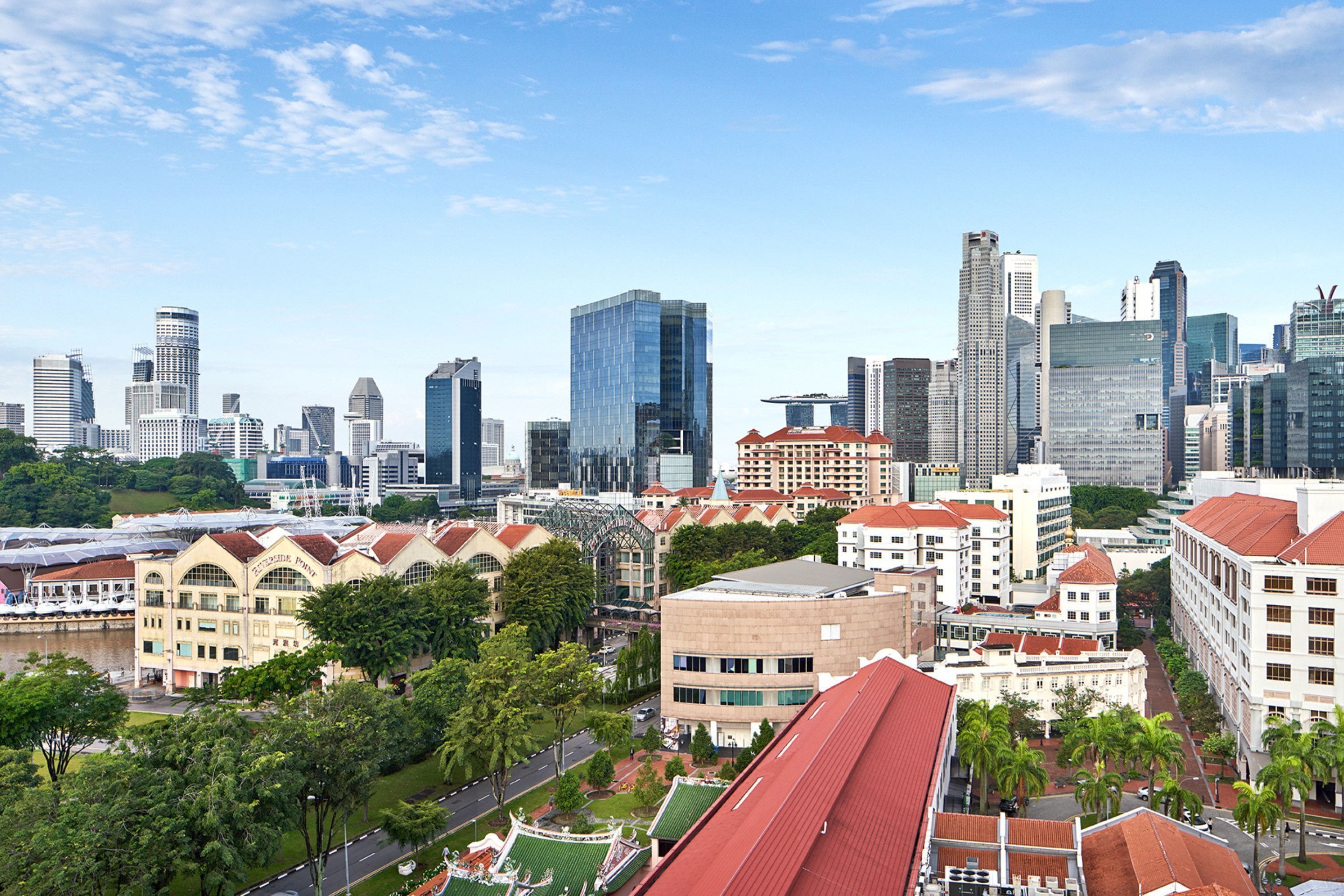 Un paisaje urbano con rascacielos modernos, edificios históricos y un río.