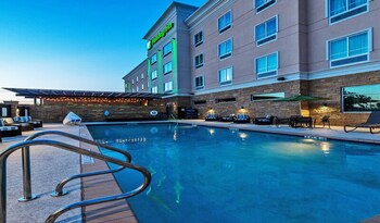 Outdoor pool, open 8 AM to 10 PM, sun loungers at Holiday Inn Austin Airport by IHG