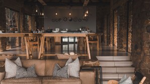 A cozy living area with a sofa, coffee table, and a dining table set with dishes.