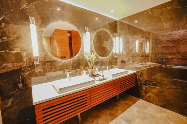 A modern bathroom with two sinks, a vanity, and a bathtub.