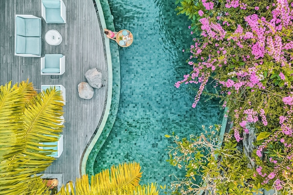 Una piscina al aire libre, sombrillas, tumbonas