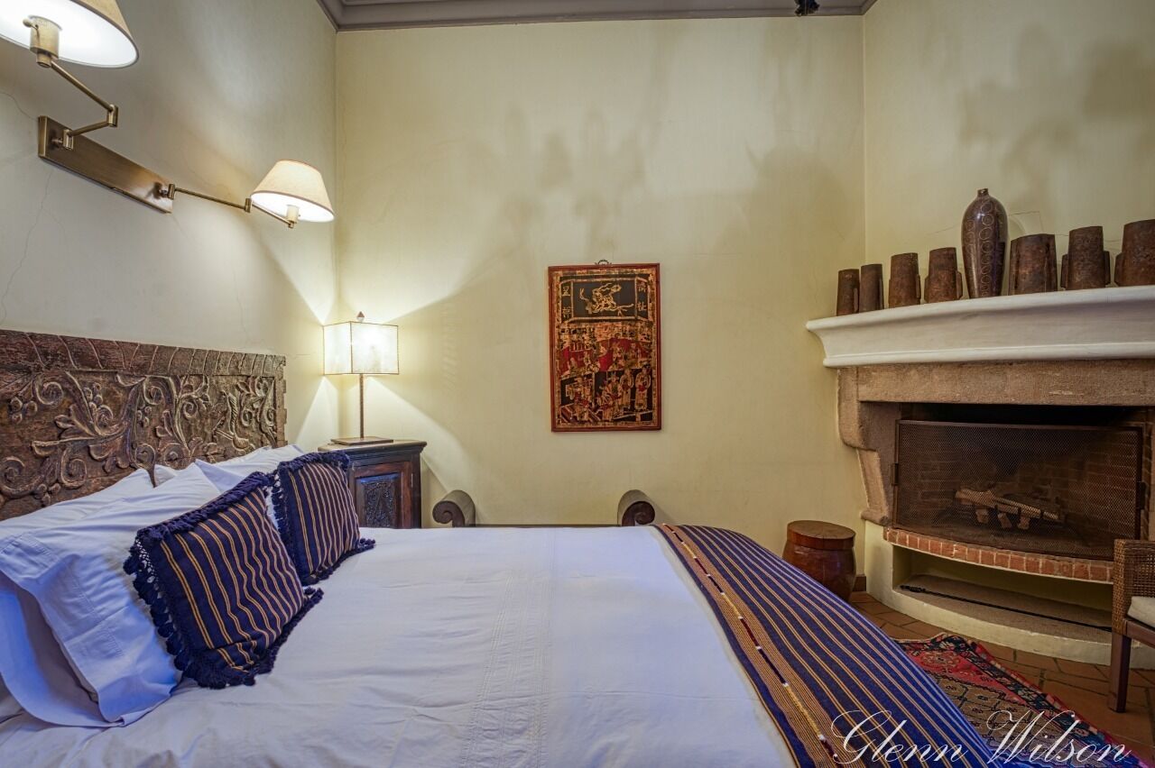 Un dormitorio con una cama grande, una chimenea y un tapiz decorativo.