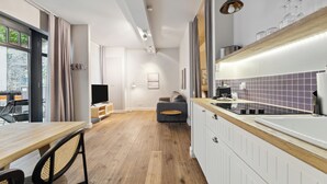 Een moderne keuken met een houten aanrecht, een inbouwoven en een eethoek met een houten tafel en stoelen.