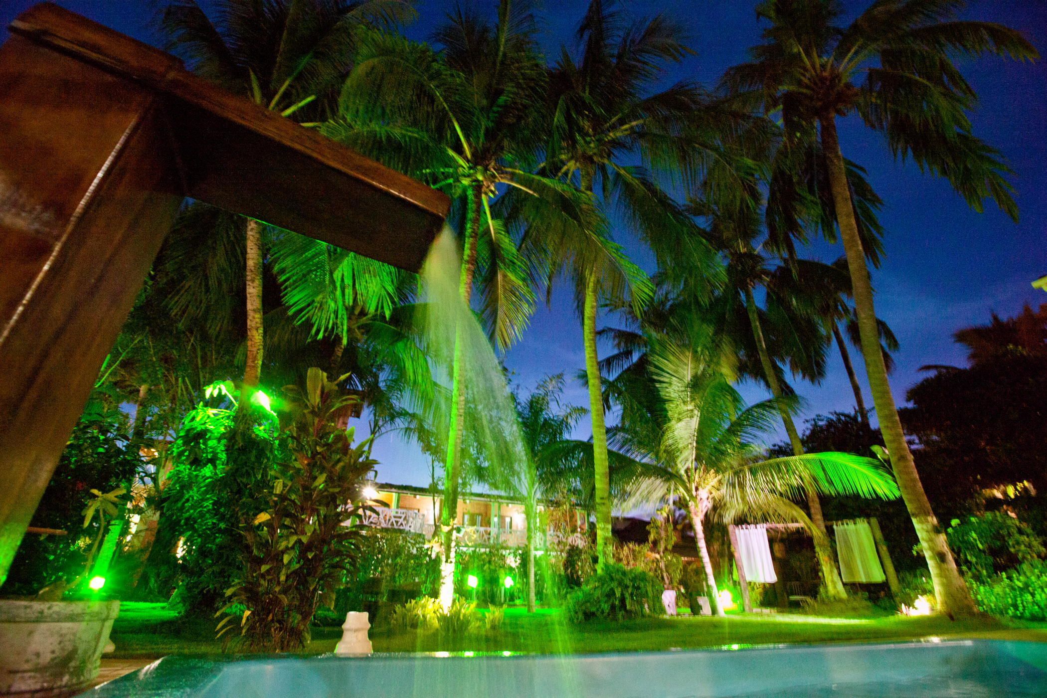 A pool area with palm trees and a building in the background.