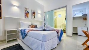 A modern hotel room with a neatly made bed, a small bedside table, and a wall-mounted shelf. - Pousada Lua Cheia (Marechal Deodoro)