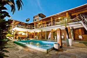 A pool area with a hot tub, lounge chairs, and a staircase leading to an upper level. - Pousada Lua Cheia (Marechal Deodoro)